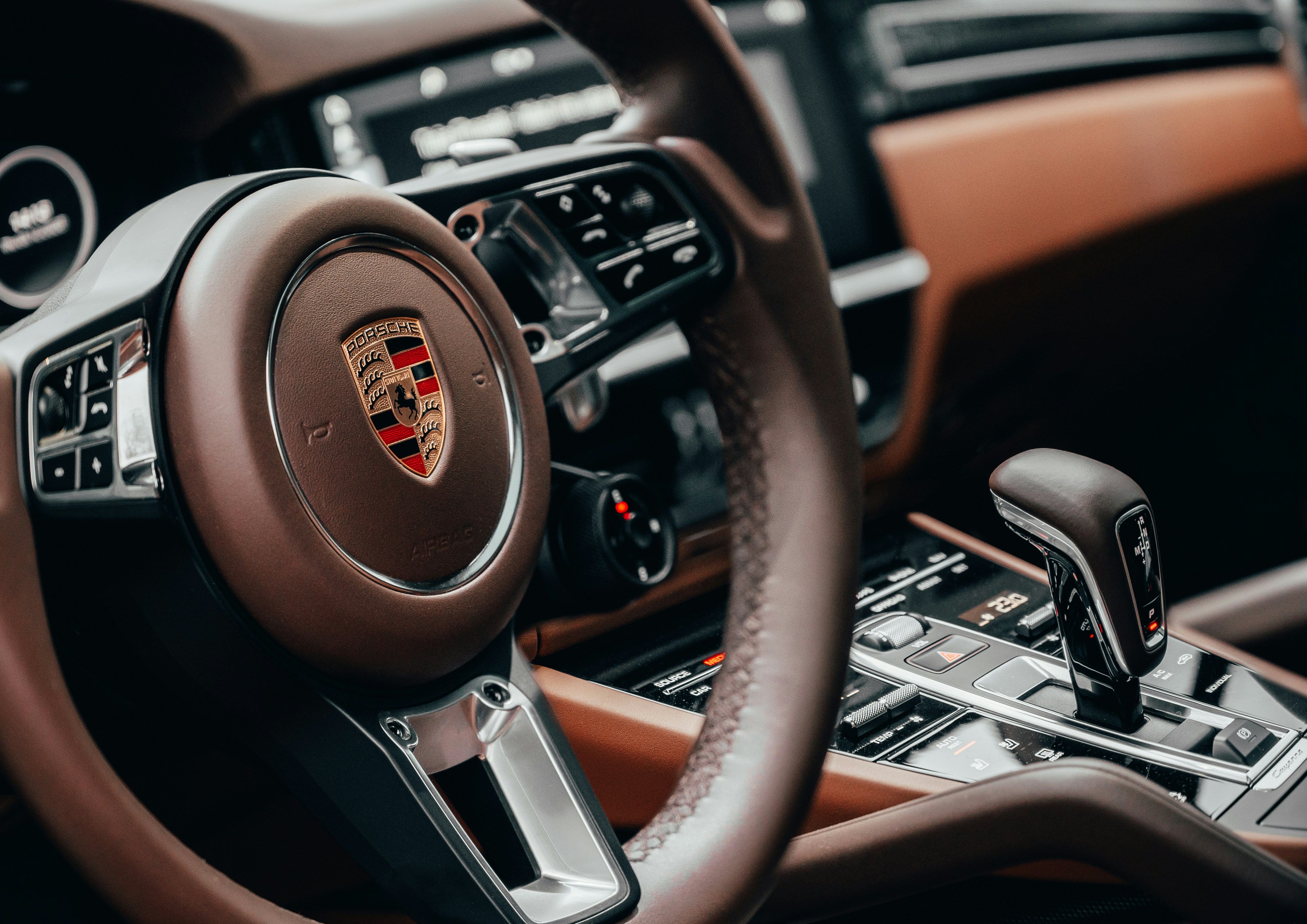 Porsche interior with brown leather steering wheel and crest